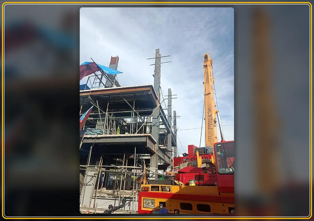 Crane supporting structural beam work on a Pasig construction project
